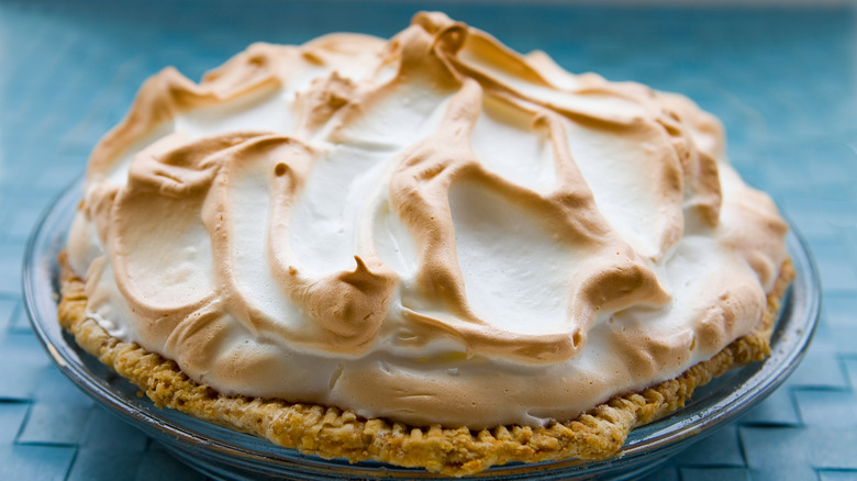 browned top meringue in glass dish on blue surface