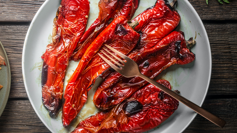 roasted peppers on white plate with bronze fork