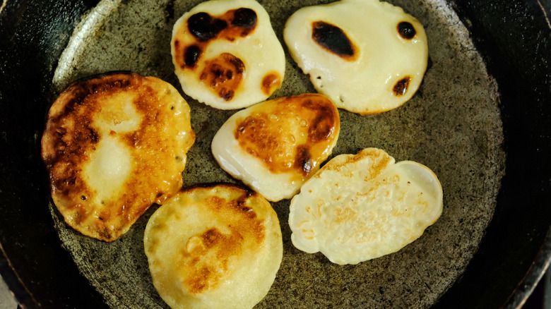 Burnt and undercooked pancakes in cast iron skillet