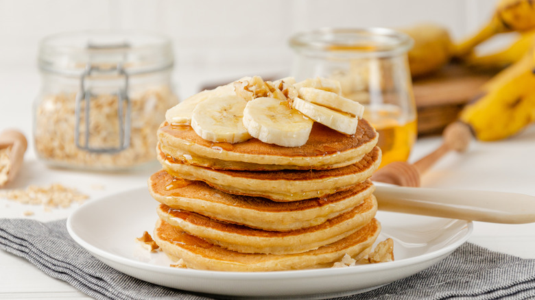 Stack of golden pancakes with banana slices