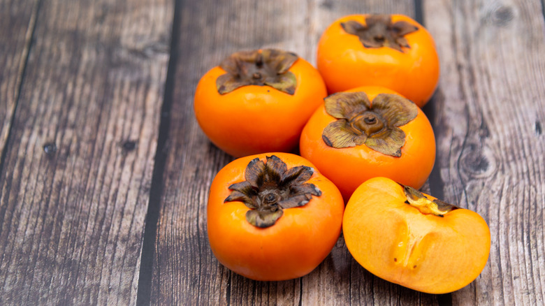 Persimmon fruits on a wooden board