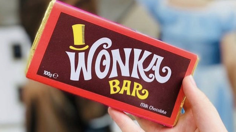 Hand holding gold wrapped Wonka Bar