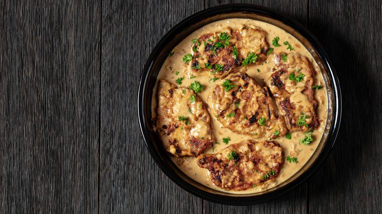 Pork chops in a bowl of gravy