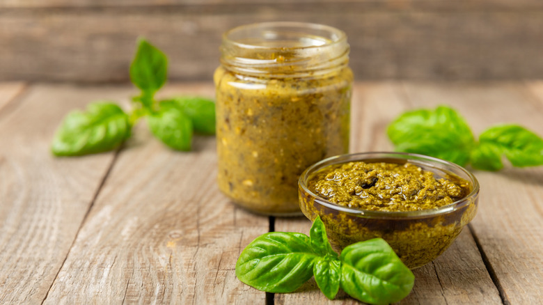 Bowl and jar of pesto with basil