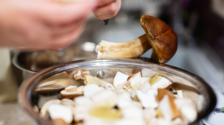 Person cutting mushrooms into a bowl