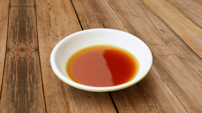 Red orange sauce in white dish on a wooden table