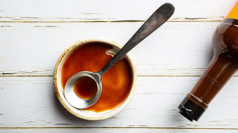 Worcestershire sauce in a ramekin with a spoon and a bottle