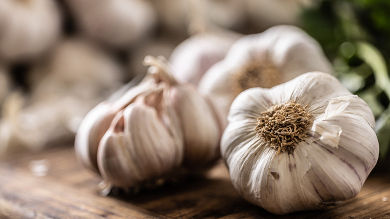 Whole garlic cloves on cutting board