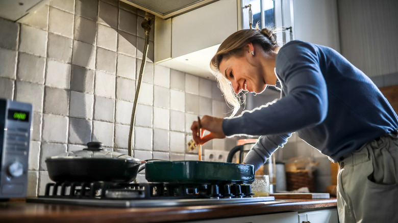 Woman leaning over pot