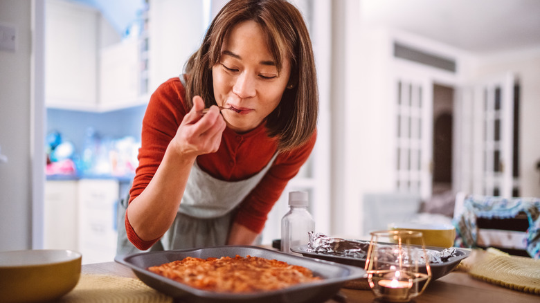 Woman tasting plate of food