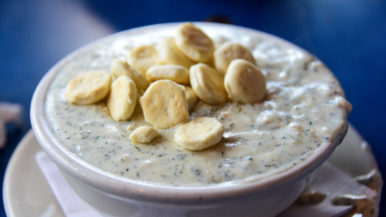 Bowl of New England clam chowder topped with oyster crackers