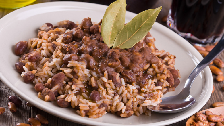 Red beans and rice on a white plate with bay leaves