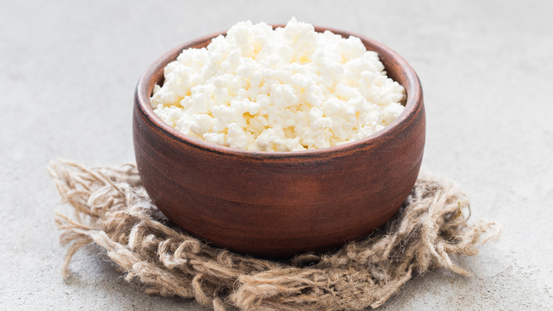 Cottage cheese in small brown wooden bowl