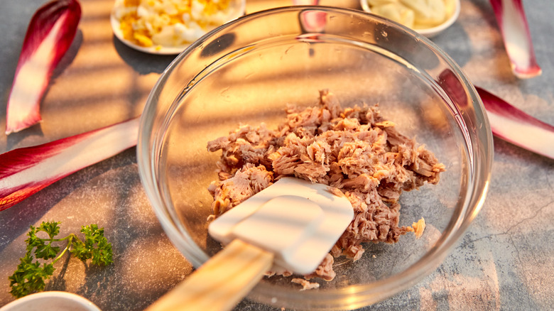 Tuna stirred with rubber spatula in a bowl