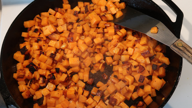 Sweet potato cooking in a cast-iron skillet