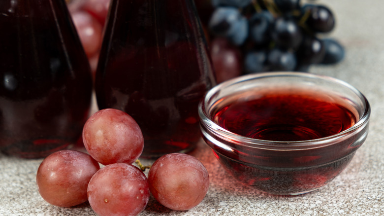 Red wine vinegar in small glass ramekin with grapes