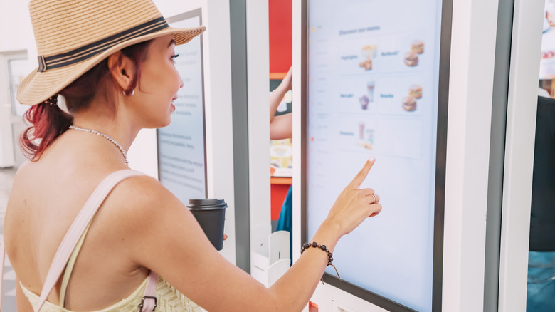 Person orders at self-service fast food kiosk