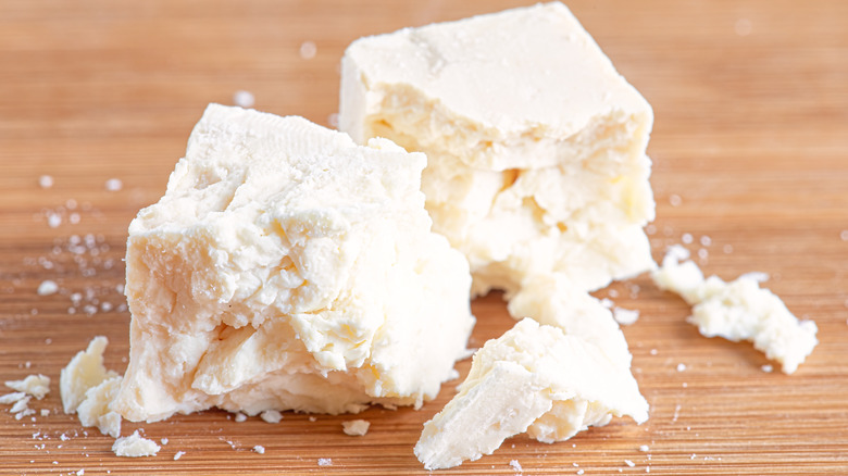 Crumbled goat cheese on a wooden board