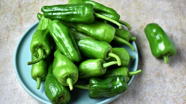 A bowl of green jalapeños on the counter