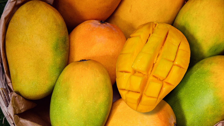 Bowl of mangoes with one sliced