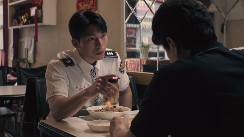 Hwang Jun ho holds vinegar in his hand, a plate of noodles in front of him