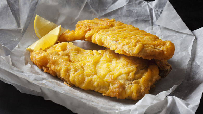 Fried fish in wax paper with lemon