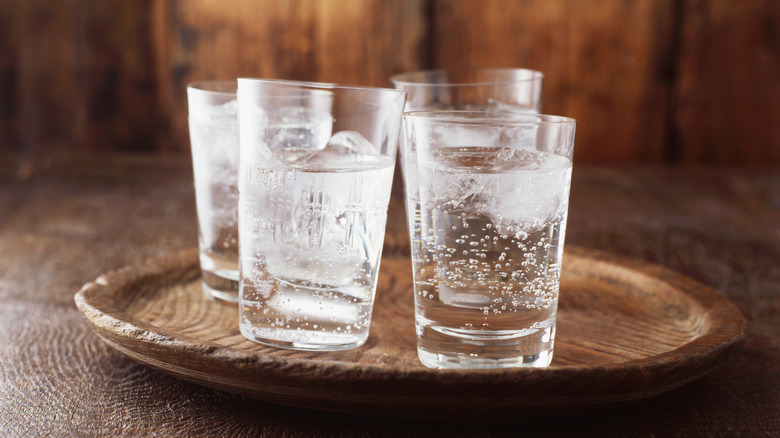 Four glasses of sparkling water on a tray