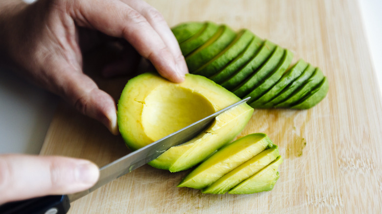 hand cutting avocado