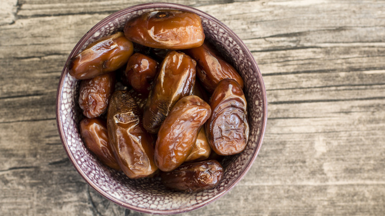 Bowl of dried dates on wooden table