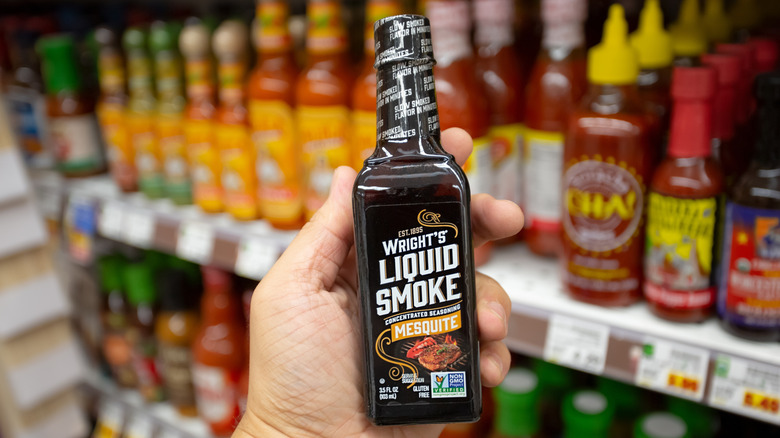 Handheld bottle of Wright's liquid smoke in grocery store