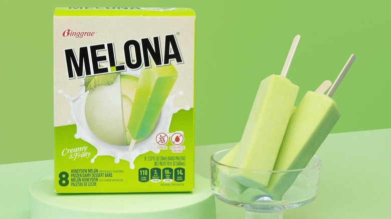 glass of melona bars next to box on green background