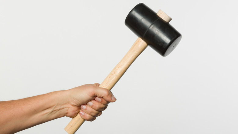 Hand holding rubber mallet
