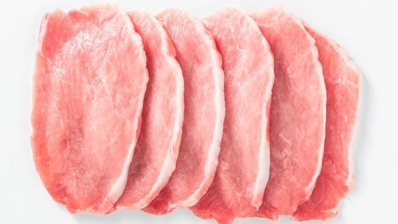 uncooked pork loin slices against a white background