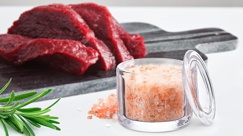 KooK glass salt cellar with pink Himalayan salt inside and raw meat in the background