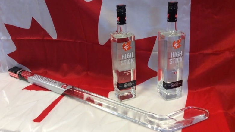 Canadian flag with three bottles of High Stick vodka (one shaped like a hockey stick)