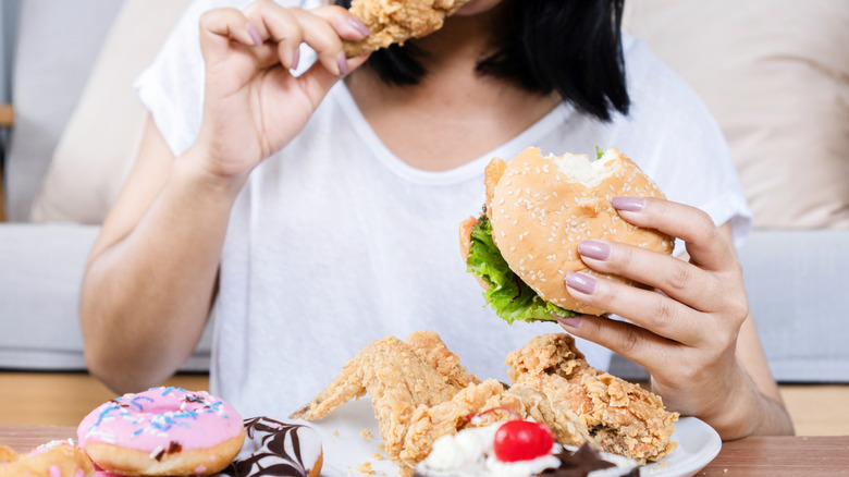 A woman eating an exorbitant amount of food