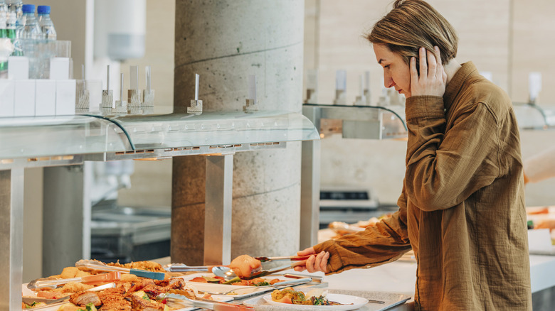 Woman looking around buffet stations