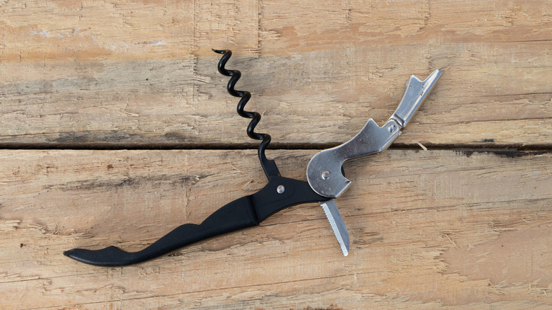 an open waiter's corkscrew on a wooden table