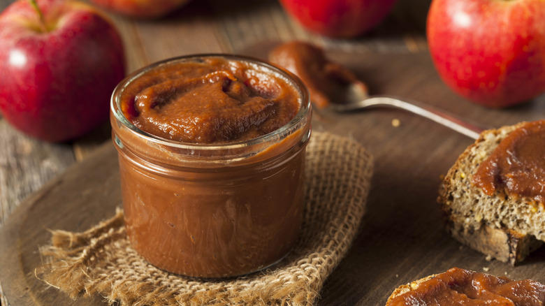 Apple butter in a jar with apples