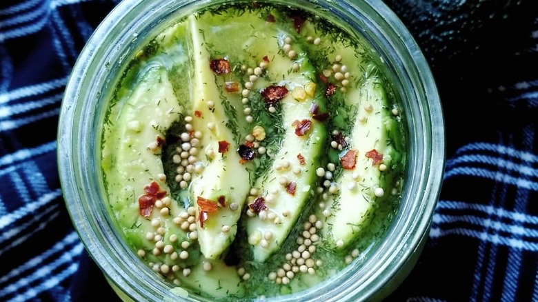 sliced pickled avocado in a blue bowl with other ingredients