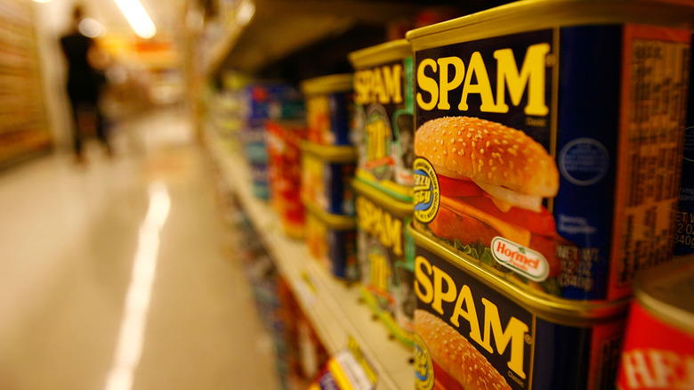 Cans of Spam sitting on a grocery store shelf