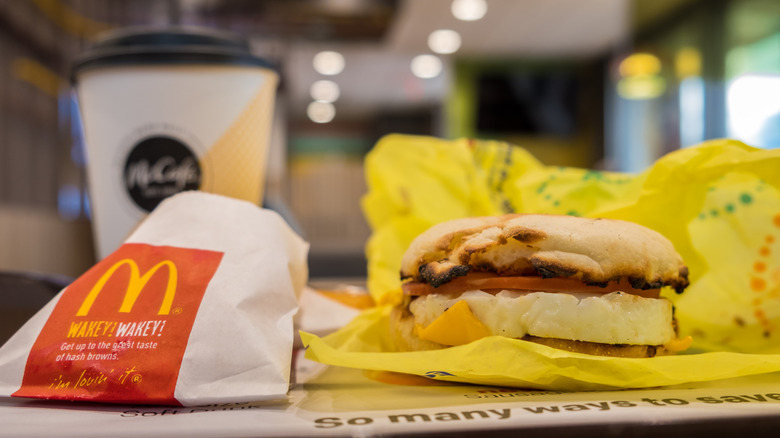 Egg McMuffin unwrapped on table with coffee