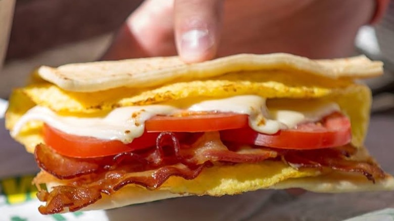 Person holding Subway breakfast sandwich