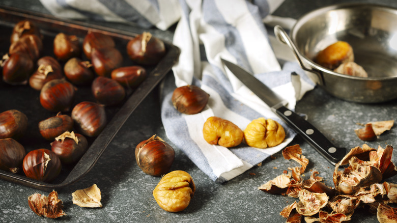 Shelled chestnuts beside a pan of roasted chestnuts