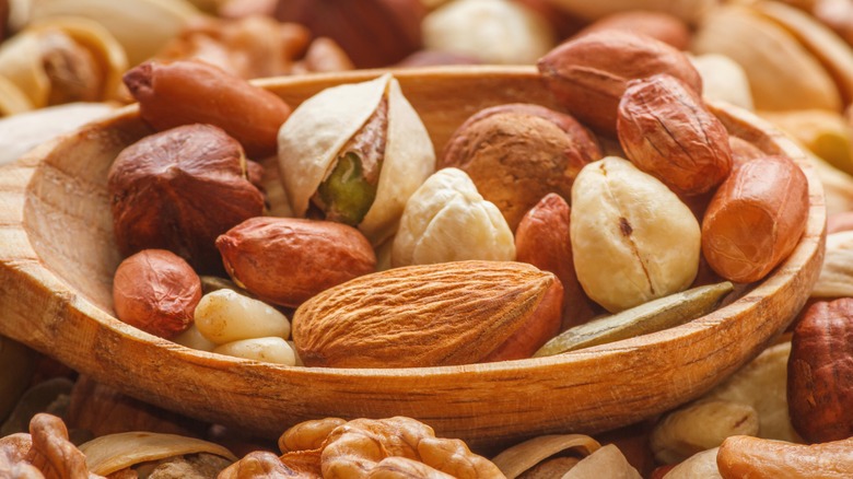 Wooden spoon filled with different types of nuts