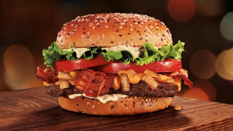 Burger with bacon, tomato, lettuce, and sauce