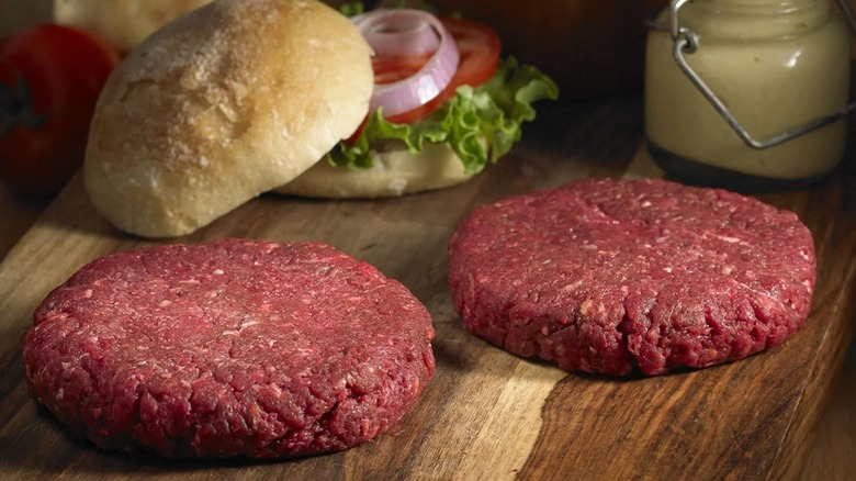 Costco's bison burger patties with roll on wooden cutitng board