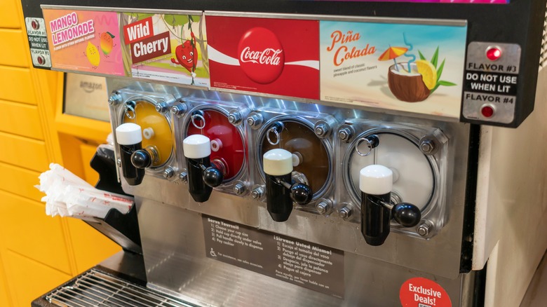 A Slurpee machine featuring mango lemonade, wild cherry, Coca Cola, and Piña Colada flavors.