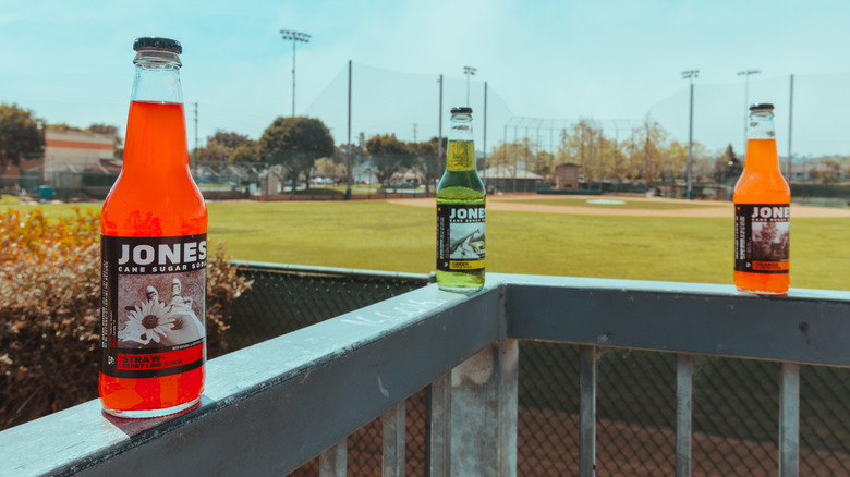 Three bottles of Jones Soda on a railing