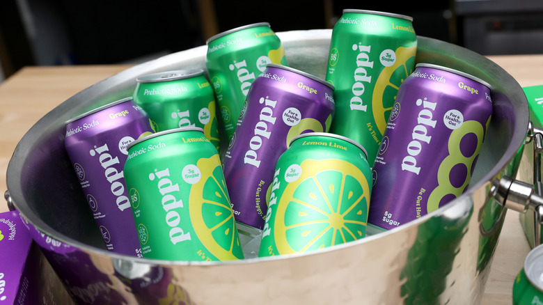 Cans of Poppi probiotic soda in metal bucket